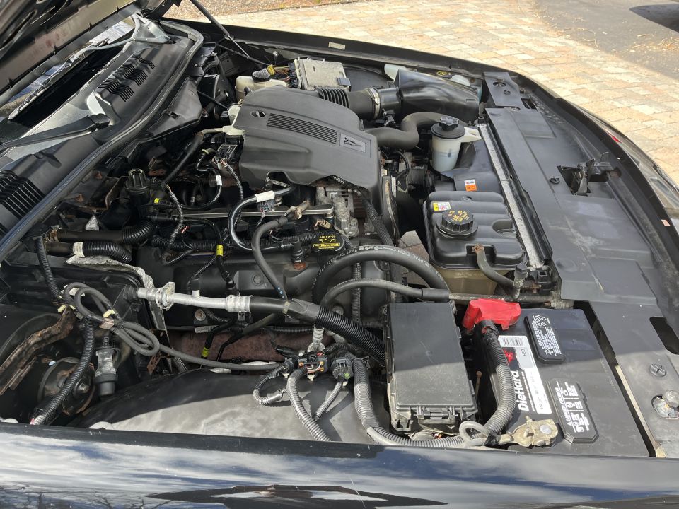 Engine compartment of a Ford Crown Victoria with battery and wiring