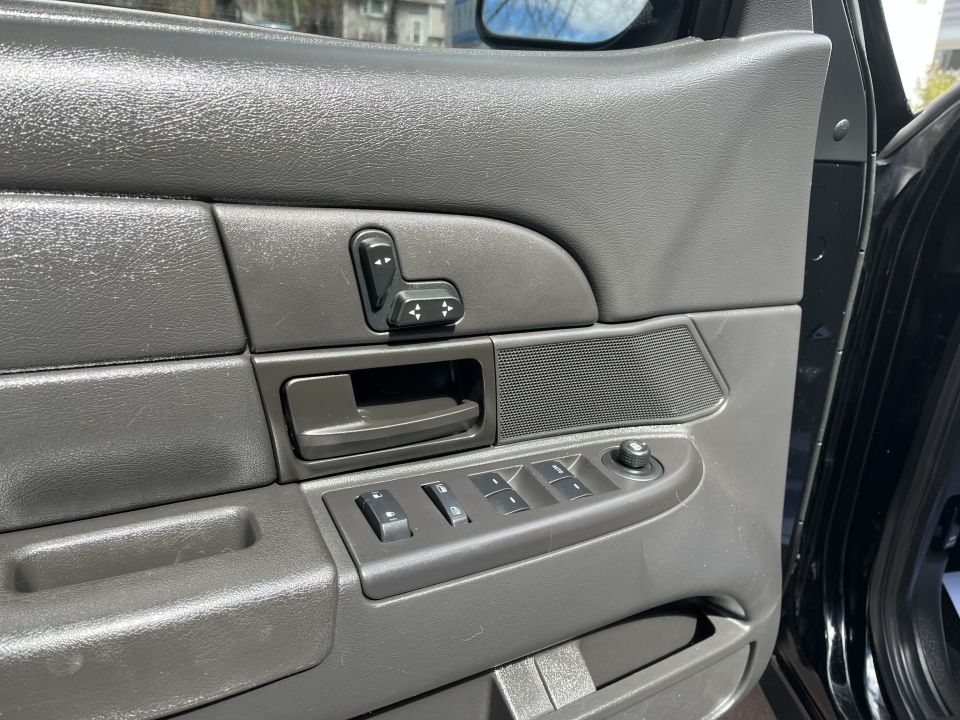 Driver door panel showing power mirror switch and master window control buttons