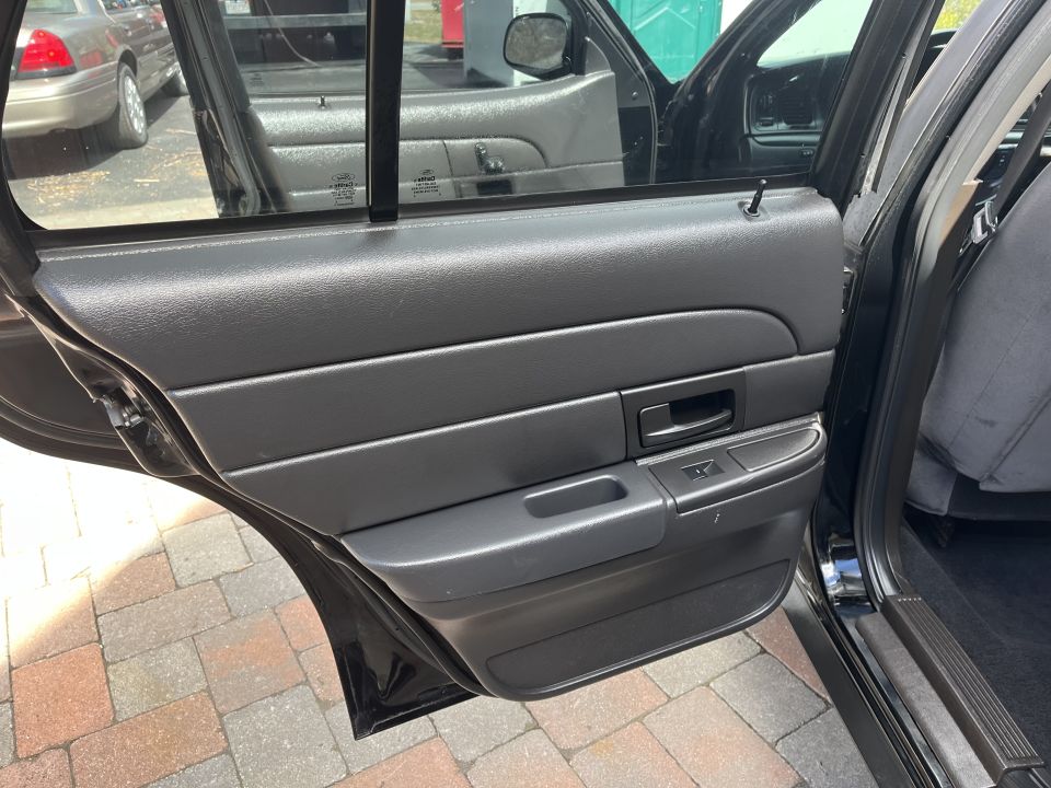 Rear passenger door panel of a Crown Victoria with armrest and switch