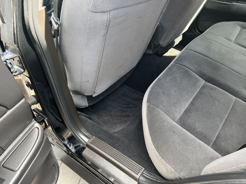 Rear floor area and front seat back of a Ford sedan interior