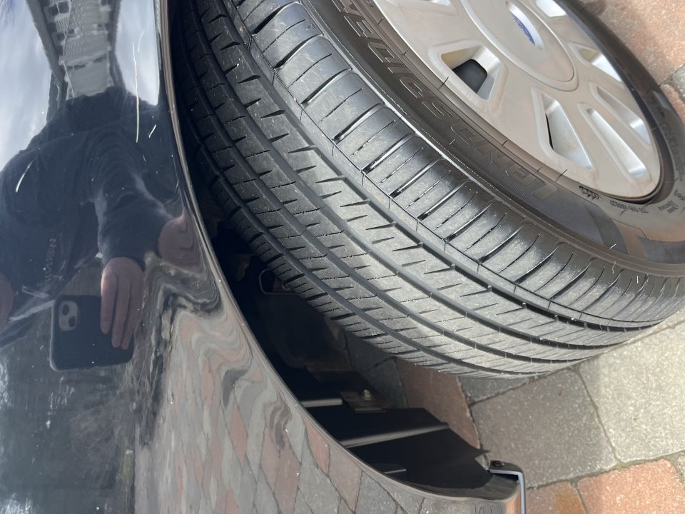 Close-up of a tire and wheel with photographer reflection