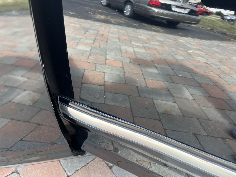 Lower body trim and rocker panel of a black car