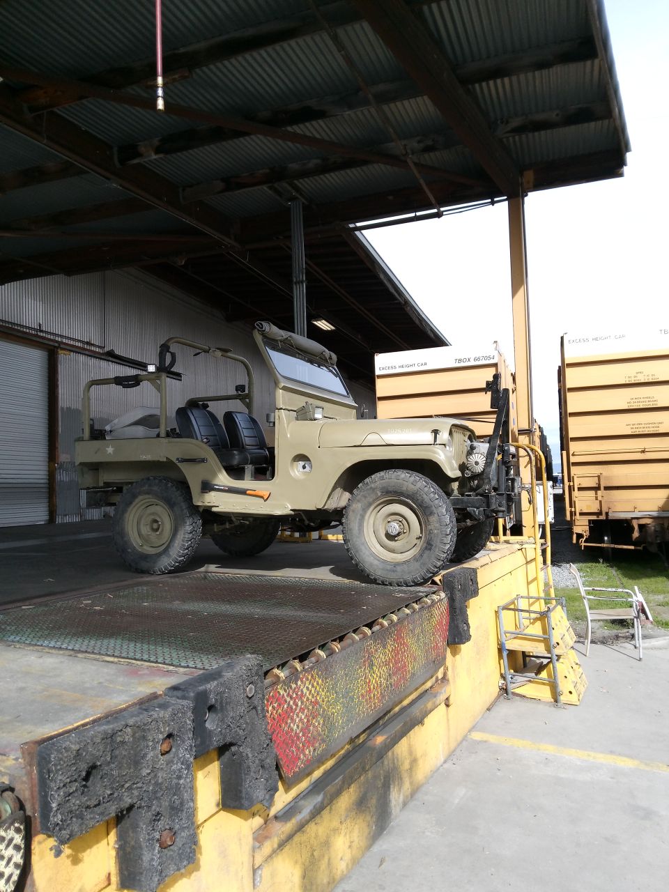 1952 Jeep CJ5 on a loading dock next to a train car.