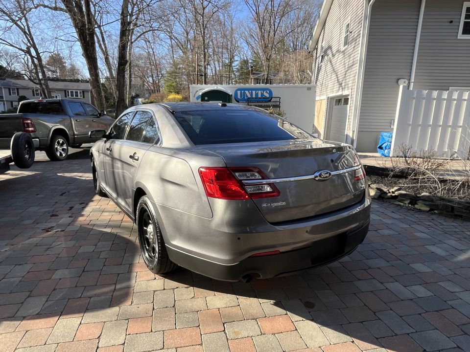 Gray Ford Taurus sedan rear quarter parked in driveway