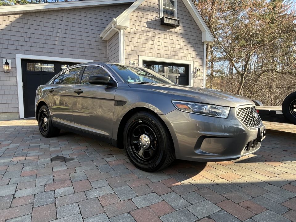 Gray Ford Taurus sedan front three-quarter view in driveway