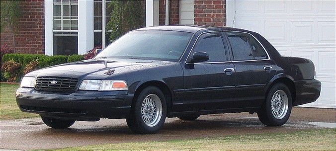 Dark sedan, 3q-front view. Matches 1998 Ford Crown Victoria