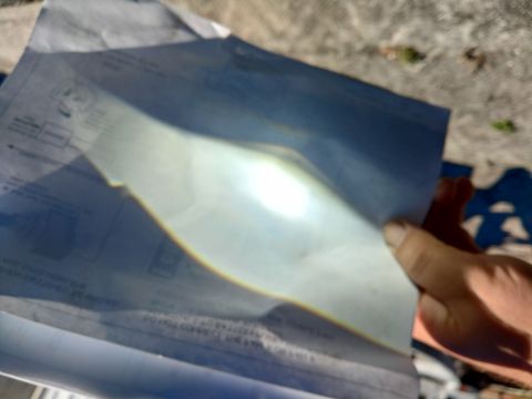 2004 Ford Expedition - A document with diagrams and text is held by a hand, illuminated by bright sunlight.