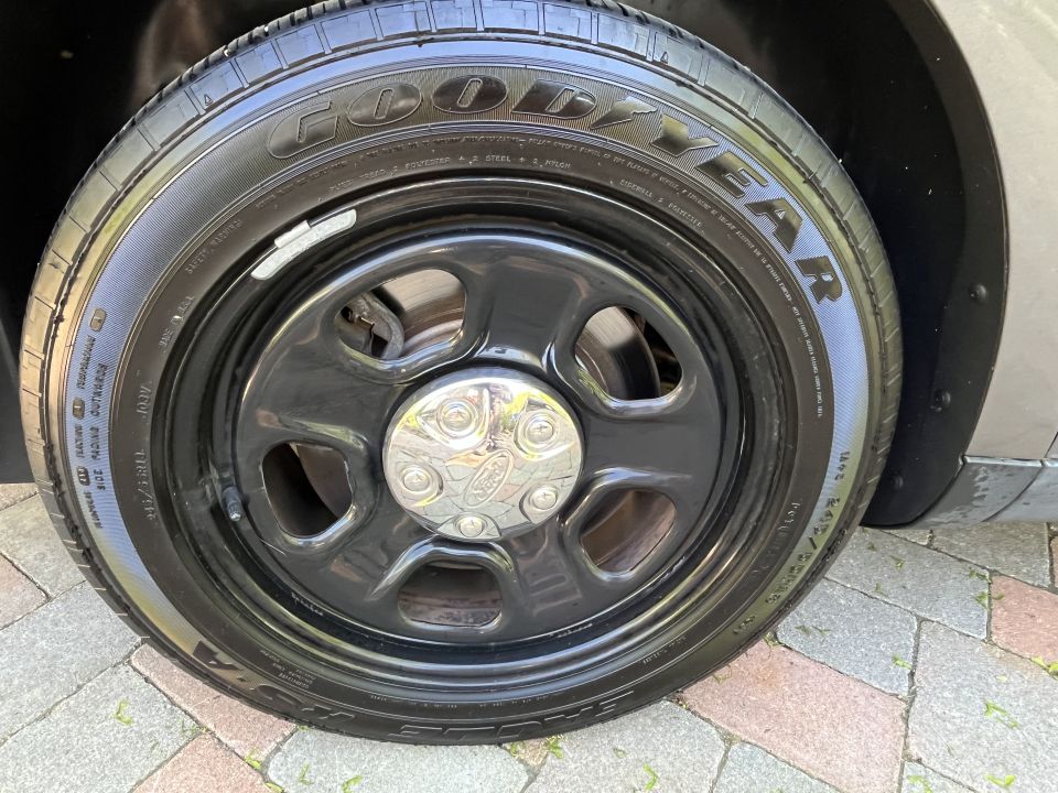 Black steel wheel with a chrome Ford center cap and Goodyear tire