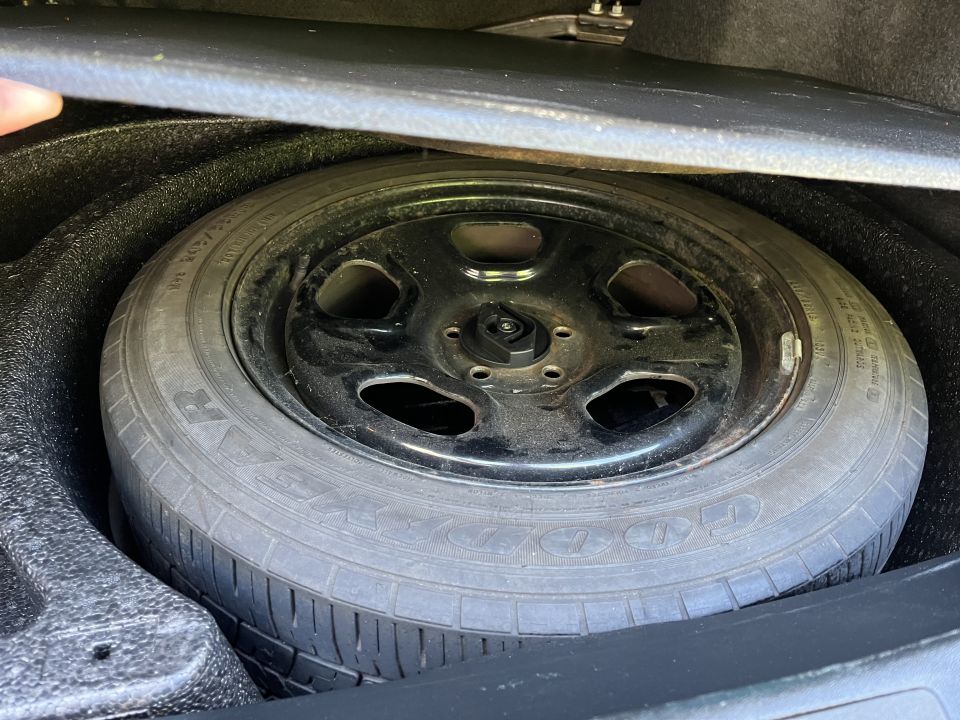 Spare tire and wheel assembly in a vehicle's trunk compartment