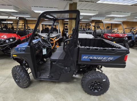 2025 Polaris RANGER - A blue side-by-side utility vehicle is parked indoors with other vehicles visible in the background.