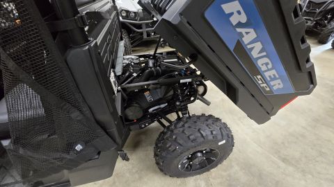 2025 Polaris RANGER - Hood open on a Polaris Ranger SP, revealing the engine compartment. Another vehicle is visible behind it.