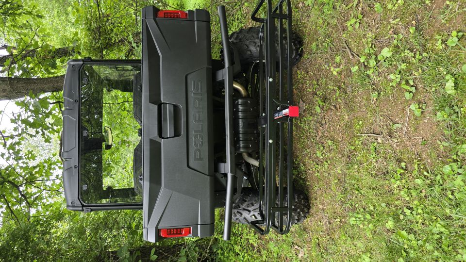 Black Polaris RANGER side-by-side, rear view, with a cargo rack and tow hitch