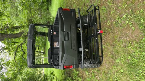 2025 Polaris RANGER - Rear view of a dark green utility vehicle with a cargo rack and "POLARIS" branding.