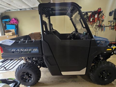 2025 Polaris RANGER - Side-by-side utility vehicle with black doors and a blue bed labeled RANGER SP, a 570 EFI badge on the hood.