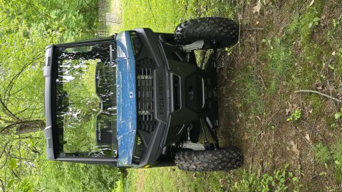 2025 Polaris RANGER - Polaris side-by-side UTV with prominent grille and headlights, seen outdoors.