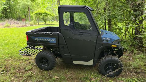 2025 Polaris RANGER - This Polaris Ranger UTV is parked outdoors in a natural setting, showing its side profile and cargo bed.