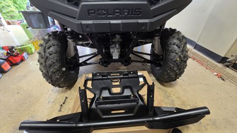 2025 Polaris RANGER - The front bumper and winch mount are laid out in front of the UTV for installation.