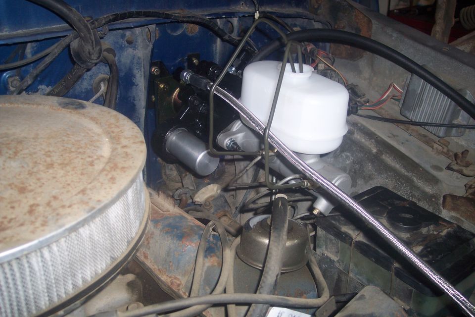 1978 Ford Bronco engine bay showing a new master cylinder and brake booster assembly with a white fluid reservoir