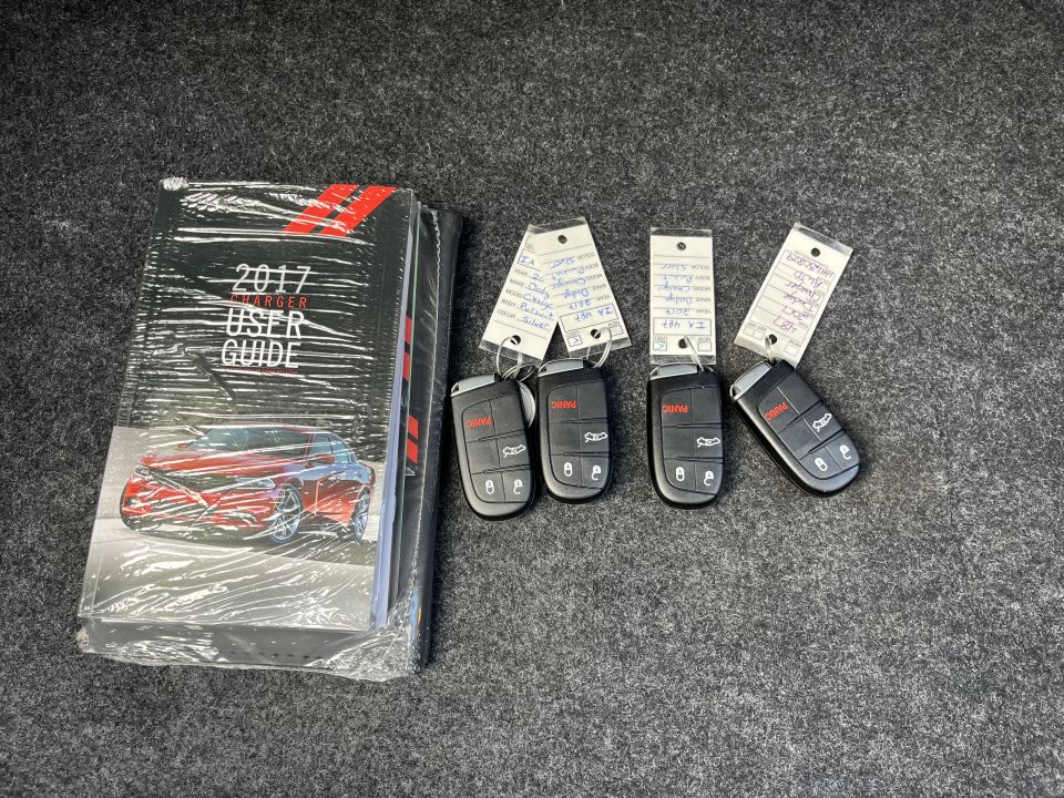 2017 user guide booklet and four Dodge key fobs on carpet