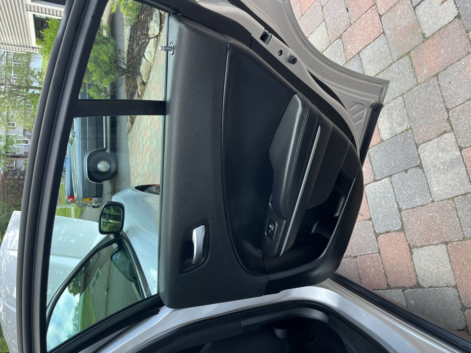 Open rear door and door panel of a silver Dodge Charger