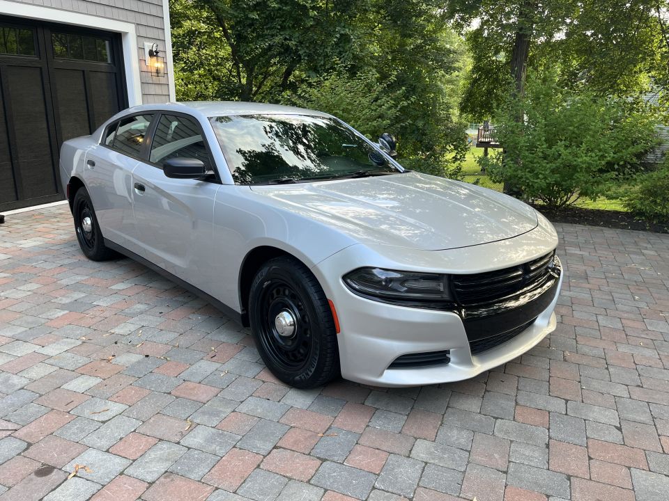 Silver Dodge Charger sedan front three-quarter view on brick driveway