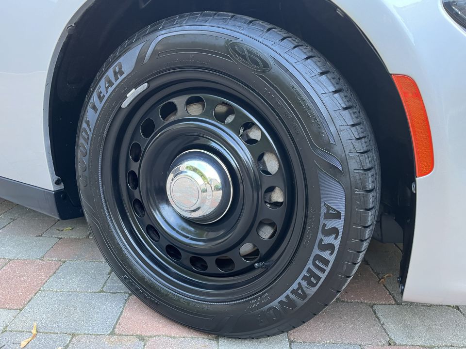 Close-up of black steel wheel and Goodyear Assurance tire on a Dodge Charger