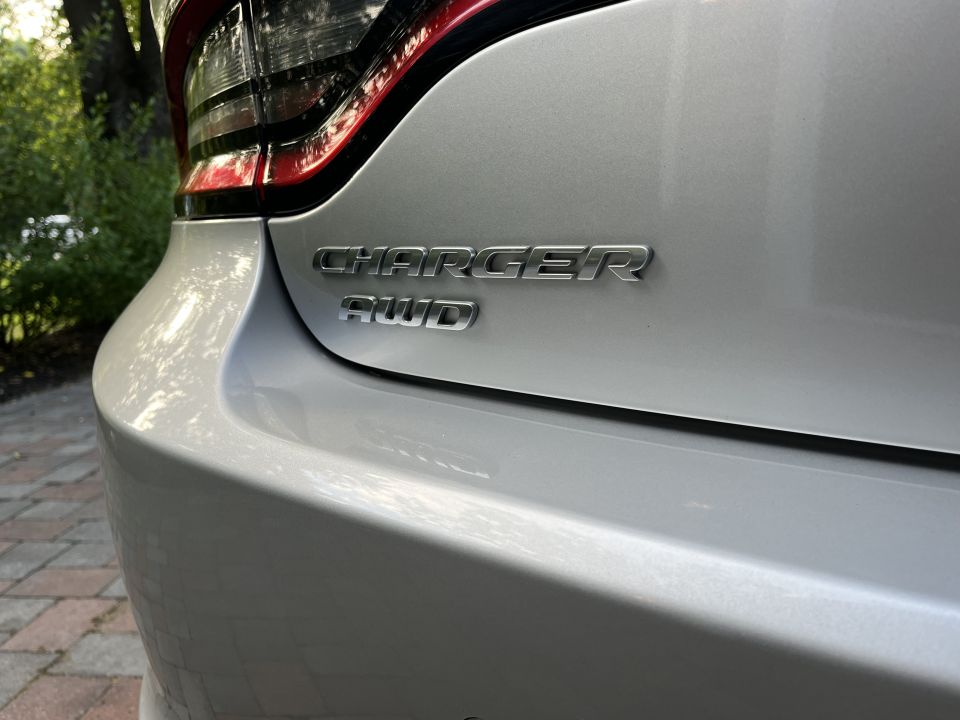 Close-up of chrome CHARGER AWD badge on a silver trunk lid