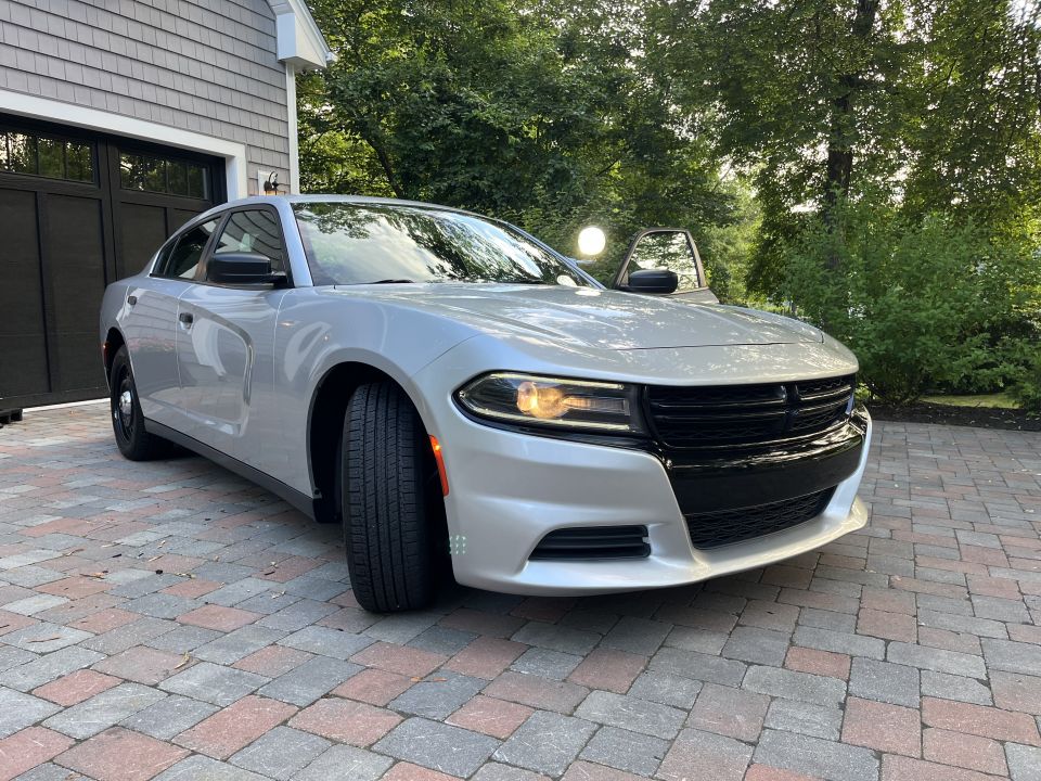 Silver Dodge Charger front three-quarter view with headlight on