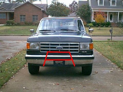1988 Ford Bronco - This Ford F-Series truck features a prominent chrome grille and bumper, with a red outline around the license plate mount.