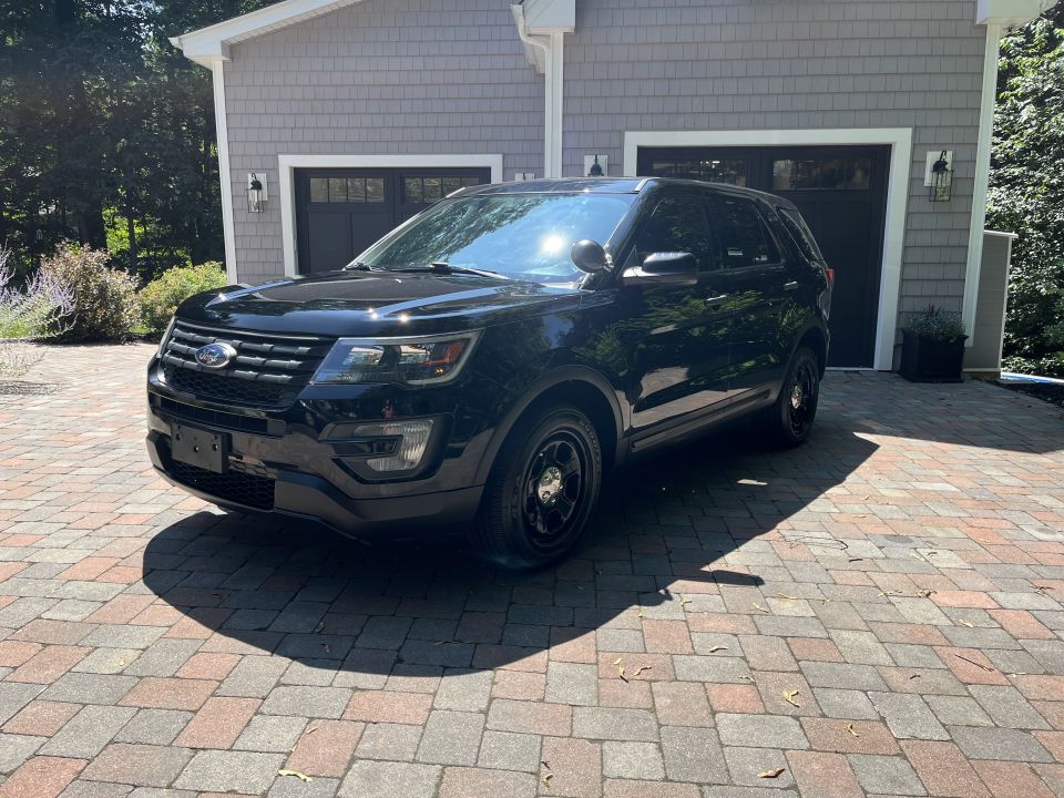 Black Ford Explorer SUV front three-quarter view on driveway