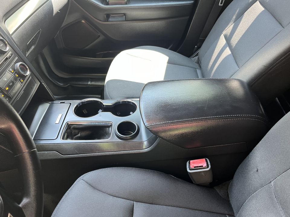Front center console with cupholders and leather armrest lid between seats