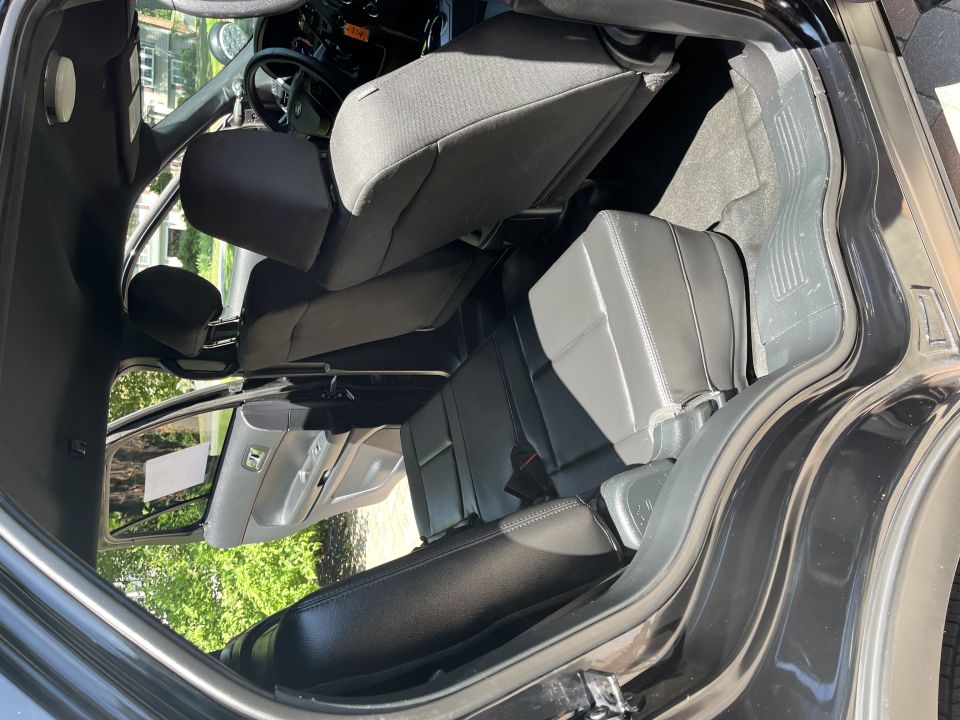 Interior view of a black SUV, showing front and rear seats, dashboard, and steering wheel