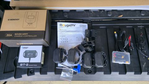 2024 Subaru Impreza - Components for a solar charge controller system are laid out, including boxes, instructions, and wiring.