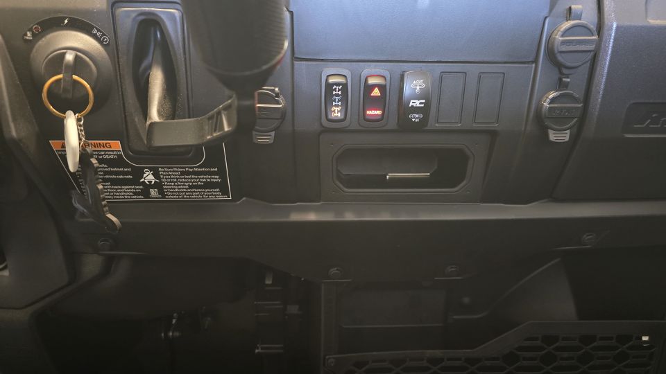 Black Polaris RANGER dash with key in ignition, hazard and RC rocker switches, and warning labels