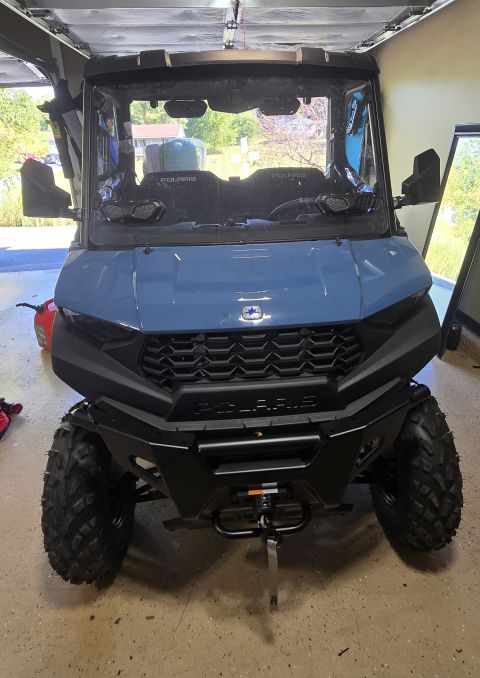 2025 Polaris RANGER - Front view of a blue utility vehicle with a black grille and bumper.