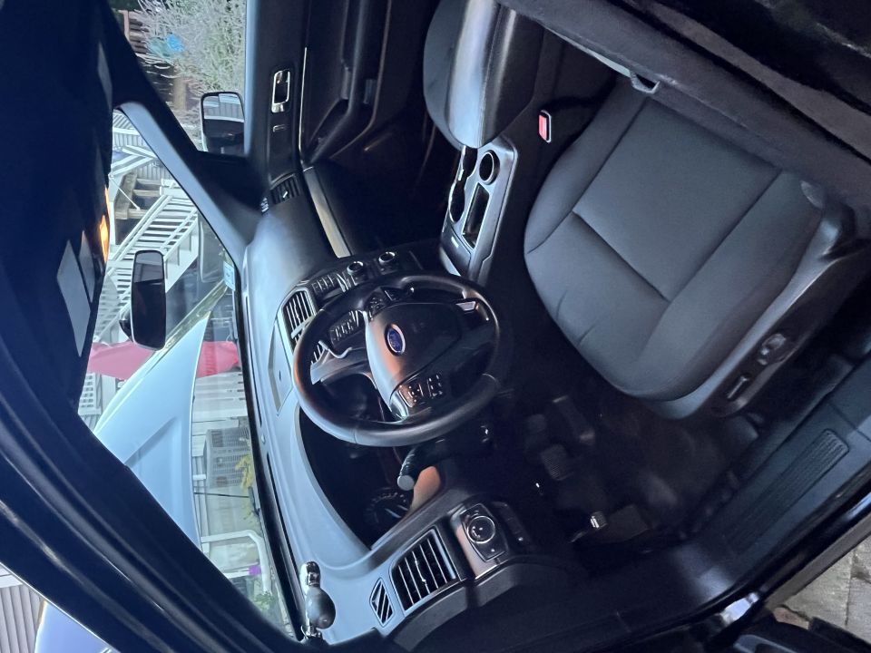 Interior of a black Ford Police Interceptor Utility, showing the steering wheel, dashboard, and front seats