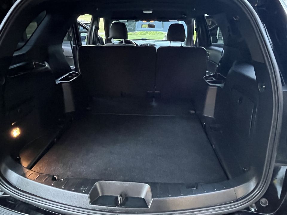 Interior cargo area of a black SUV, showing folded rear seats and the trunk floor