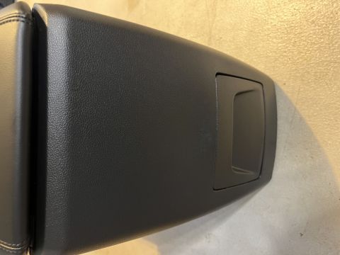 2020 Ford Explorer - Close-up of a black vehicle center console lid, showing its textured finish and a recessed compartment.