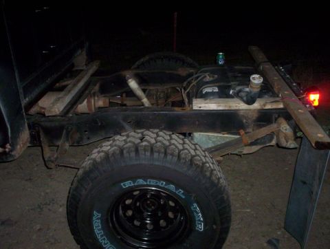 1978 Ford Bronco - The rear suspension and fuel tank of a vehicle are shown at night, with a can of soda on top of the fuel tank.