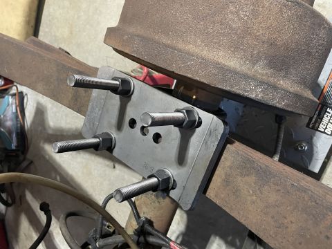 1979 Ford Bronco - Custom bracket assembly attached to a beam, with a brake drum visible overhead.