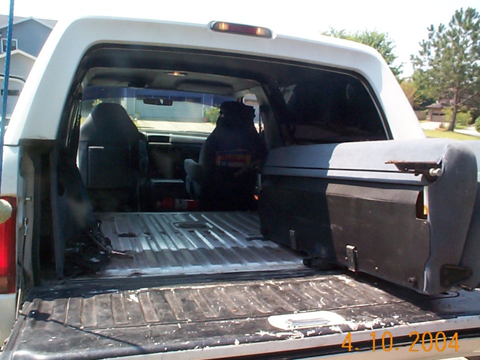 View through open rear hatch of an SUV into a stripped bare-metal cargo floor