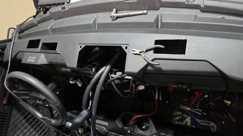 2025 Polaris RANGER - The dashboard of a utility task vehicle is shown with wiring exposed and tools nearby.