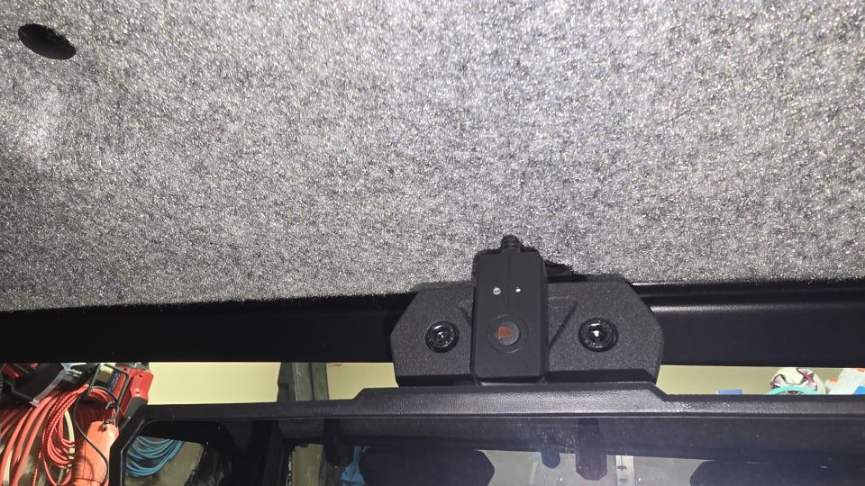 Dash cam mount attached to a vehicle's interior roof lining