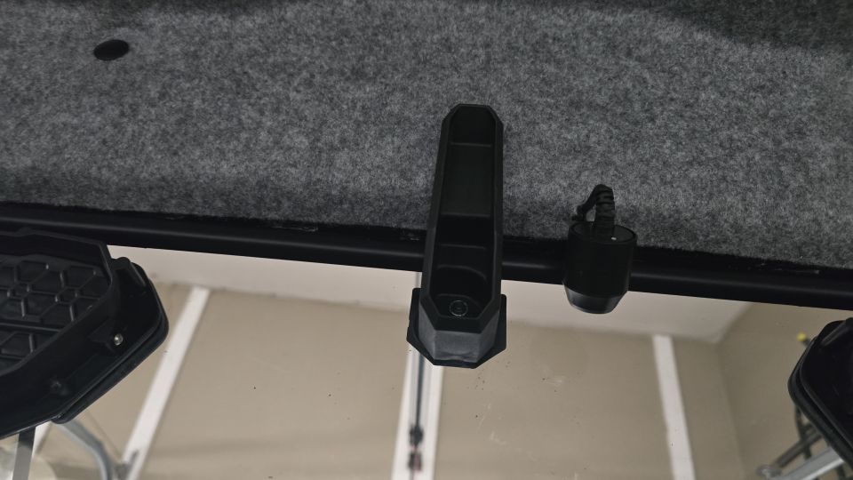 Interior roof lining and windshield frame with a black clip and a small black device attached