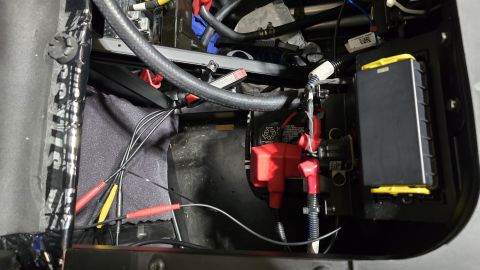 2025 Polaris RANGER - Close-up view of a vehicle's battery and electrical components, including wiring and a fuse box.