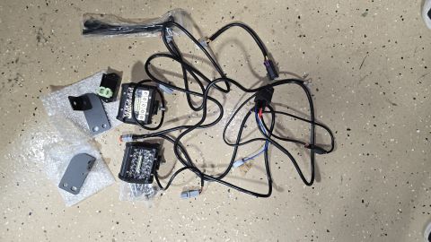 2025 Polaris RANGER - A set of two LED backup lights, wiring harness, and mounting hardware are laid out on a speckled floor.