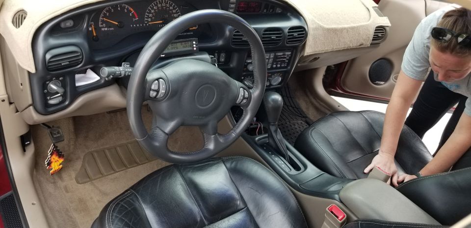 Interior of a 2002 Pontiac Grand Prix showing dashboard, steering wheel, and front seats