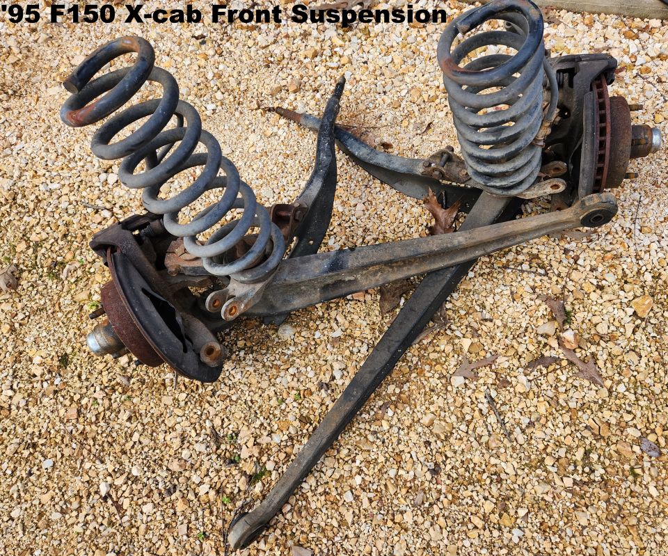 '95 F150 X-cab front suspension assembly with coil springs, spindles and radius arms on gravel