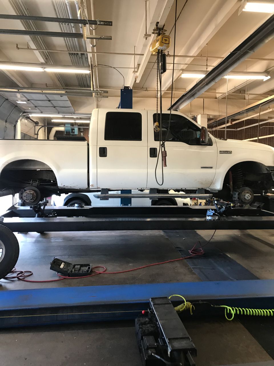 2005 Ford F-250 on a lift with wheels removed for service