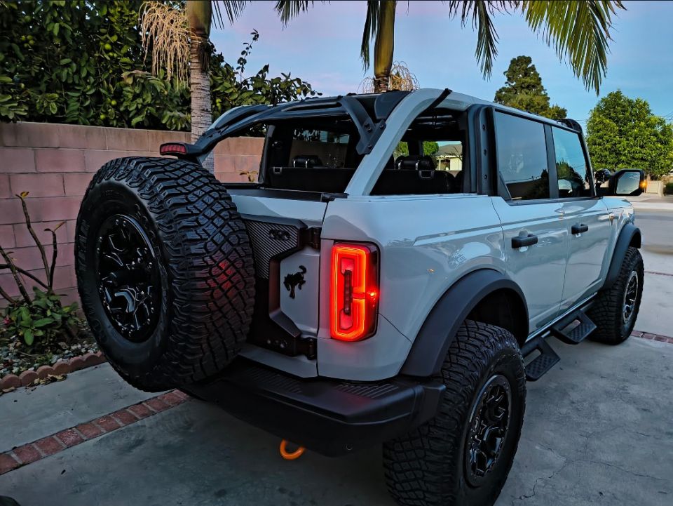 Gray Ford Bronco rear view with spare tire mounted on the back, LED taillights, and aftermarket wheels
